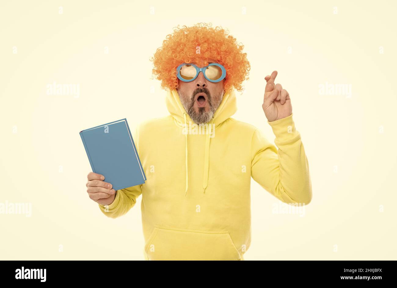 Tenere le dita incrociate. Libro superstizioso nerd hold. Studiare per l'esame. Sessione di esame Foto Stock