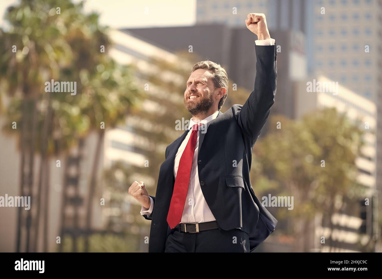 uomo felice uomo d'affari in vestito e cravatta rossa che celebra il successo di affari esprime felicità, buon affare Foto Stock