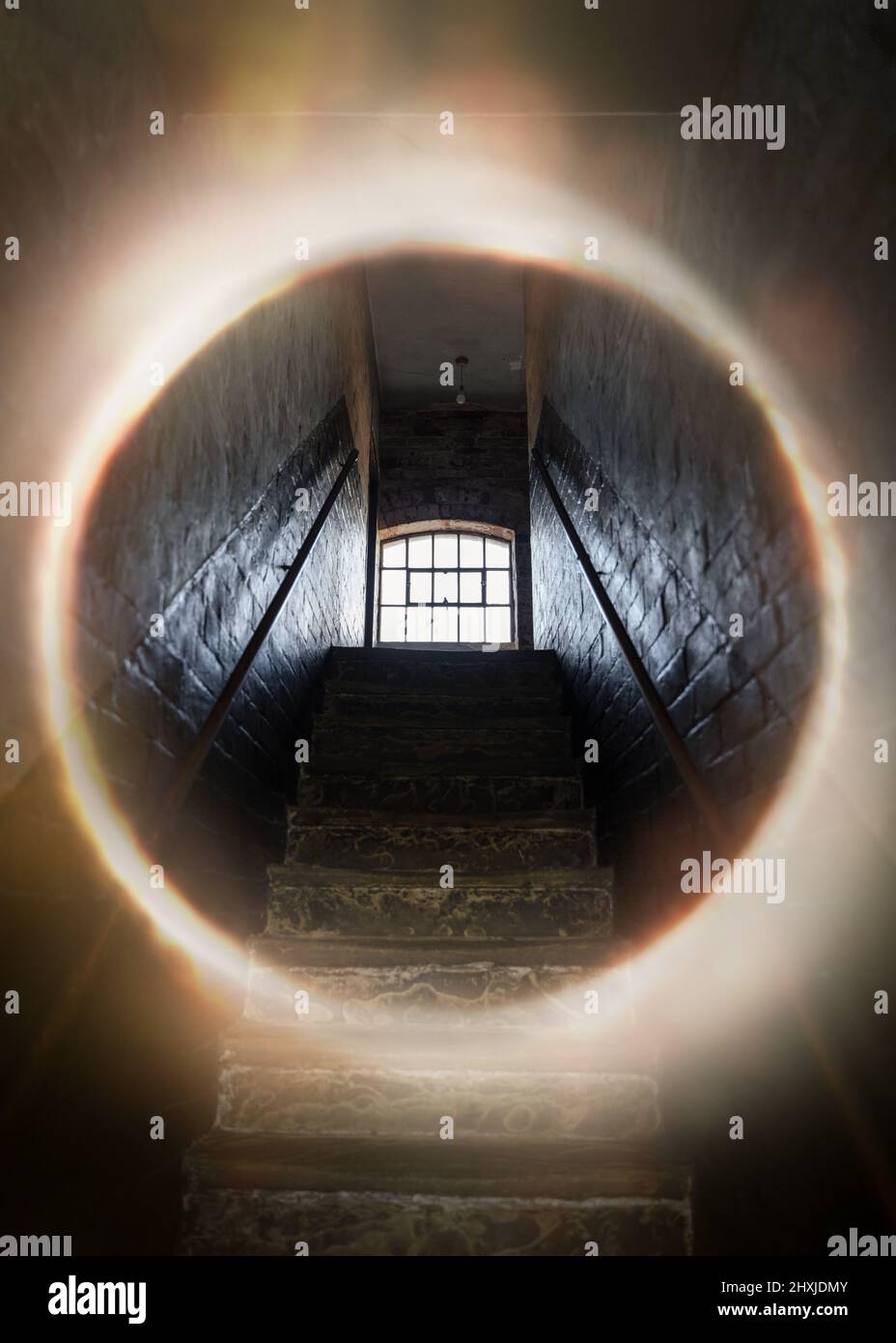La finestra scura e creepy si apre in cima a vecchie scale di pietra i raggi luminosi del sole che brillavano attraverso sul pavimento rendendo ombre e spaventoso sinistro sinistro base abbandonata Foto Stock