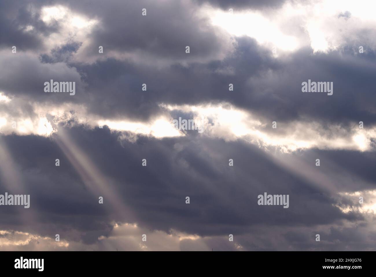 Il cielo è coperto da nuvole scure. C'è un divario nelle nuvole attraverso cui la luce del sole penetra creando nubi pittoresche. Foto Stock