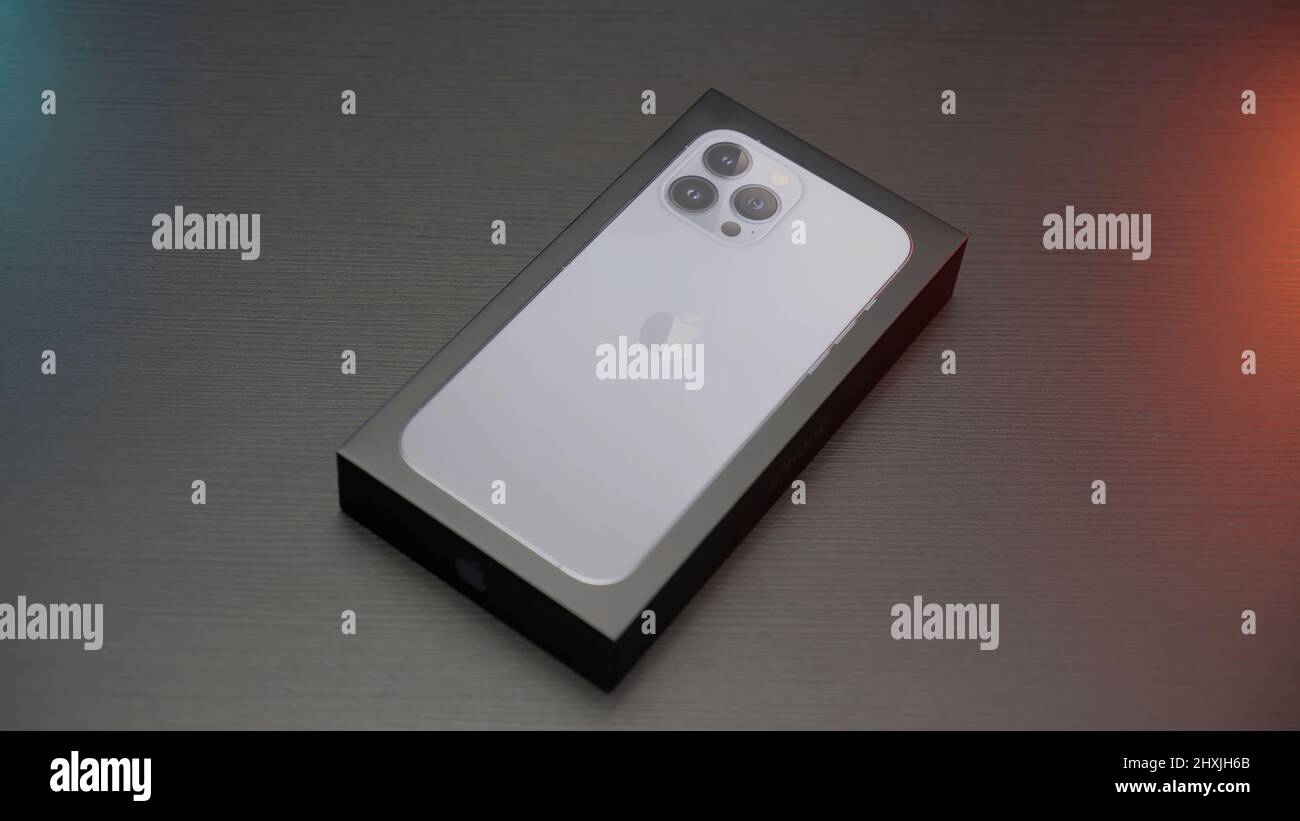 Turku - Finlandia, 10.15.2021: Nuovo iPhone 13 pro max all'interno di una scatola adagiata su un tavolo grigio scuro. Azione. Primo piano del nuovo smartphone all'interno di un pacchetto. Foto Stock