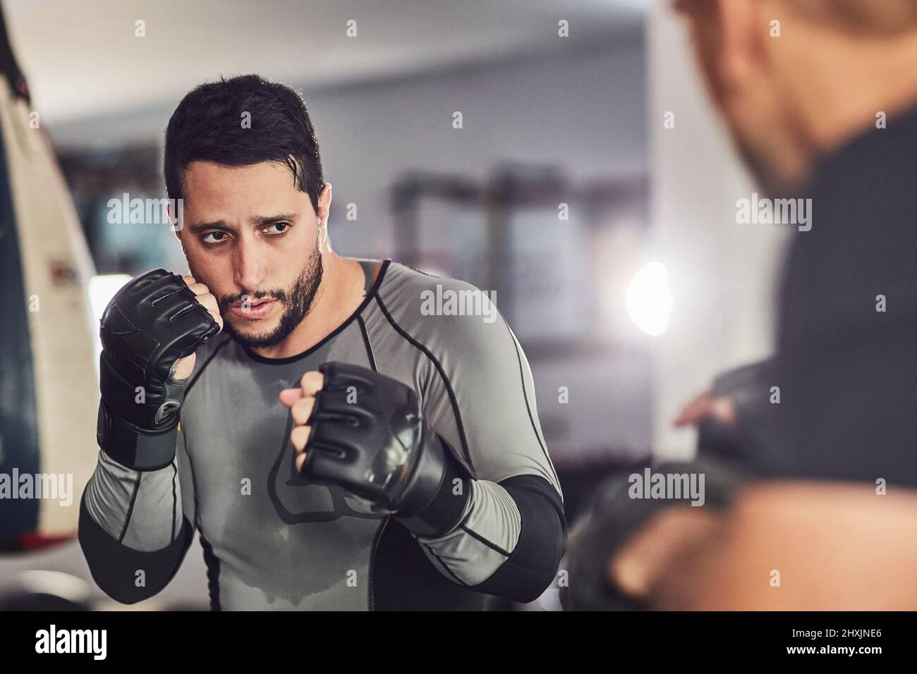 Lavorando alla sua tecnica. Scatto corto di due combattenti professionisti che sparano in palestra. Foto Stock