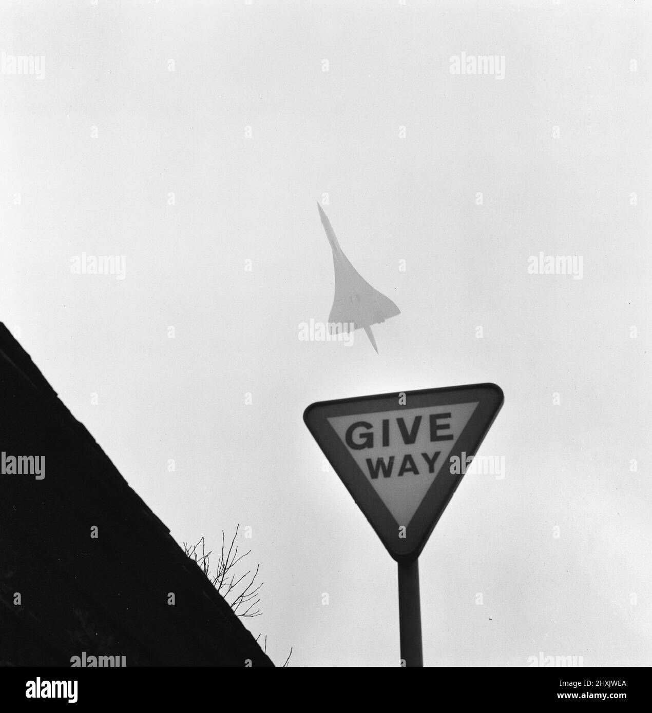 Il supersonico Airliner Concorde in volo attraverso nebbia e neve, passando un cartello con la scritta Give Way come parte dall'aeroporto di Heathrow lungo il tragitto per il clima più caldo del Bahrain in Medio Oriente. 4th febbraio 1976. Foto Stock