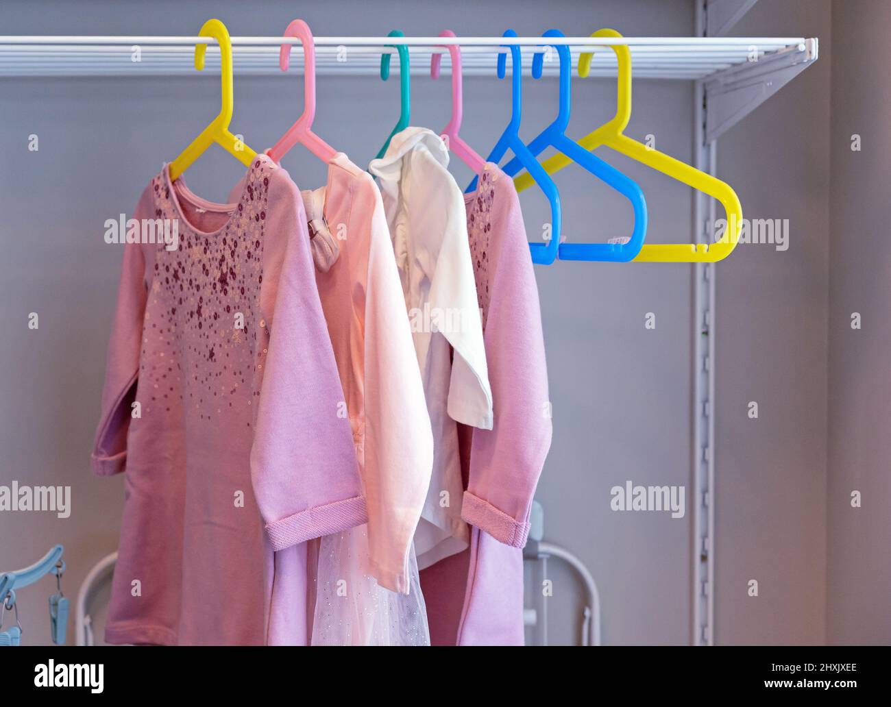 Abiti per bambini su appendiabiti colorati. Abbigliamento per bambini, negozi per bambini. Foto Stock
