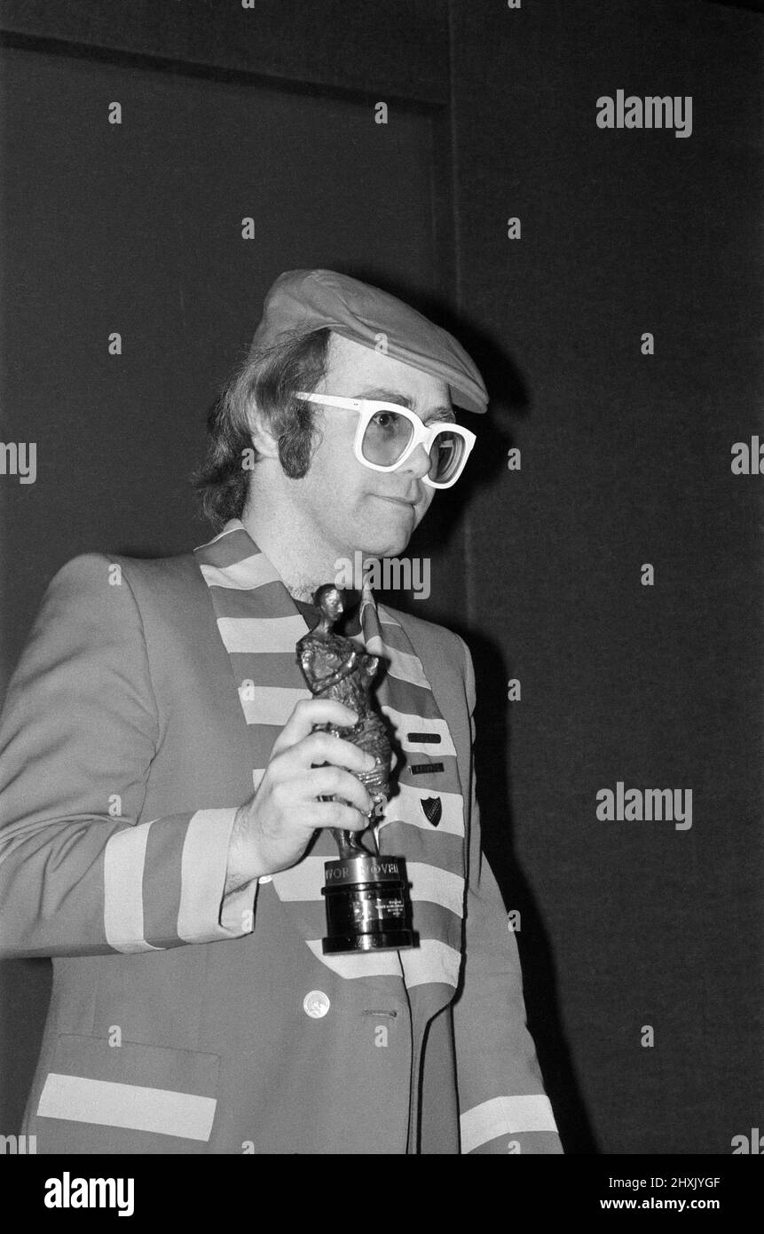 La ventiduesima Ivor Novello Awards, presentato da Bosch e sponsorizzato da PRS. Presso la struttura Grosvenor House Hotel di Londra. Elton John nella foto con il suo statuetta per la migliore canzone pop 'Dsu¿ andare rompendo il mio cuore" . Il 12 maggio 1977. Foto Stock
