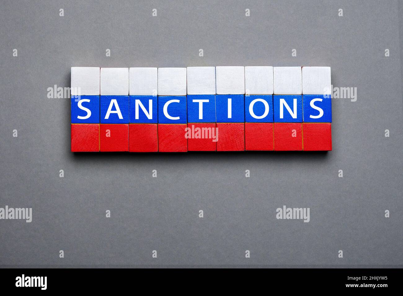 Blocco di legno giocattolo cubi lettere concetto sanzioni messaggio testo isolato bandiera. Sanzioni economiche bandiera russa colori legno cubi stack blocchi lettere legno Foto Stock
