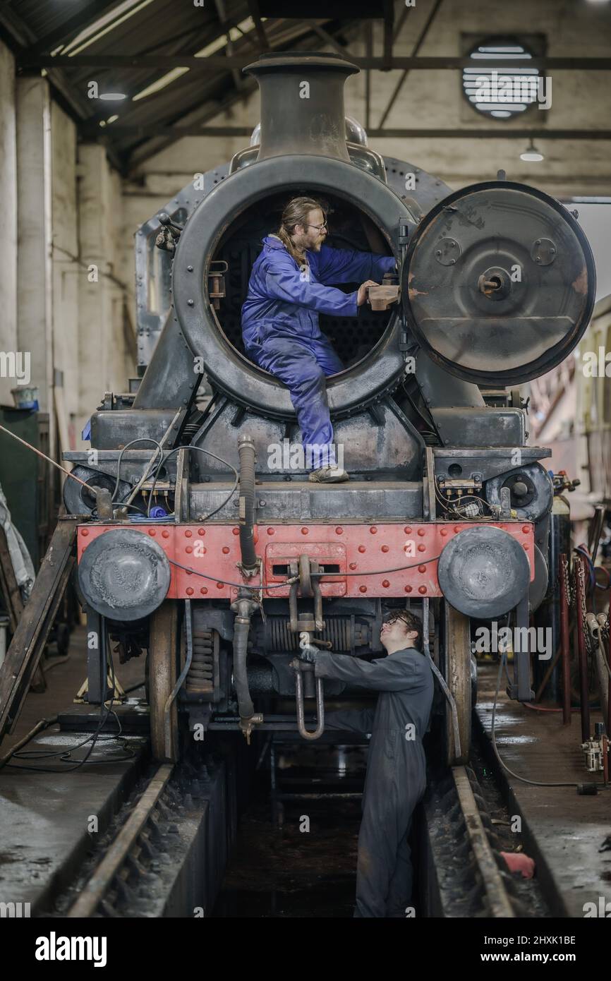 Gli ingegneri ispezionano una locomotiva a vapore Ivatt 2mt nei capannoni motore a Cranmore sulla East Somerset Railway, mentre i fine settimana a vapore iniziano a tornare alla normalità dopo la pandemia del coronavirus e le ferrovie storiche si sono prefissate per la stagione primaverile in tutto il paese. Data foto: Domenica 13 marzo 2022. Foto Stock