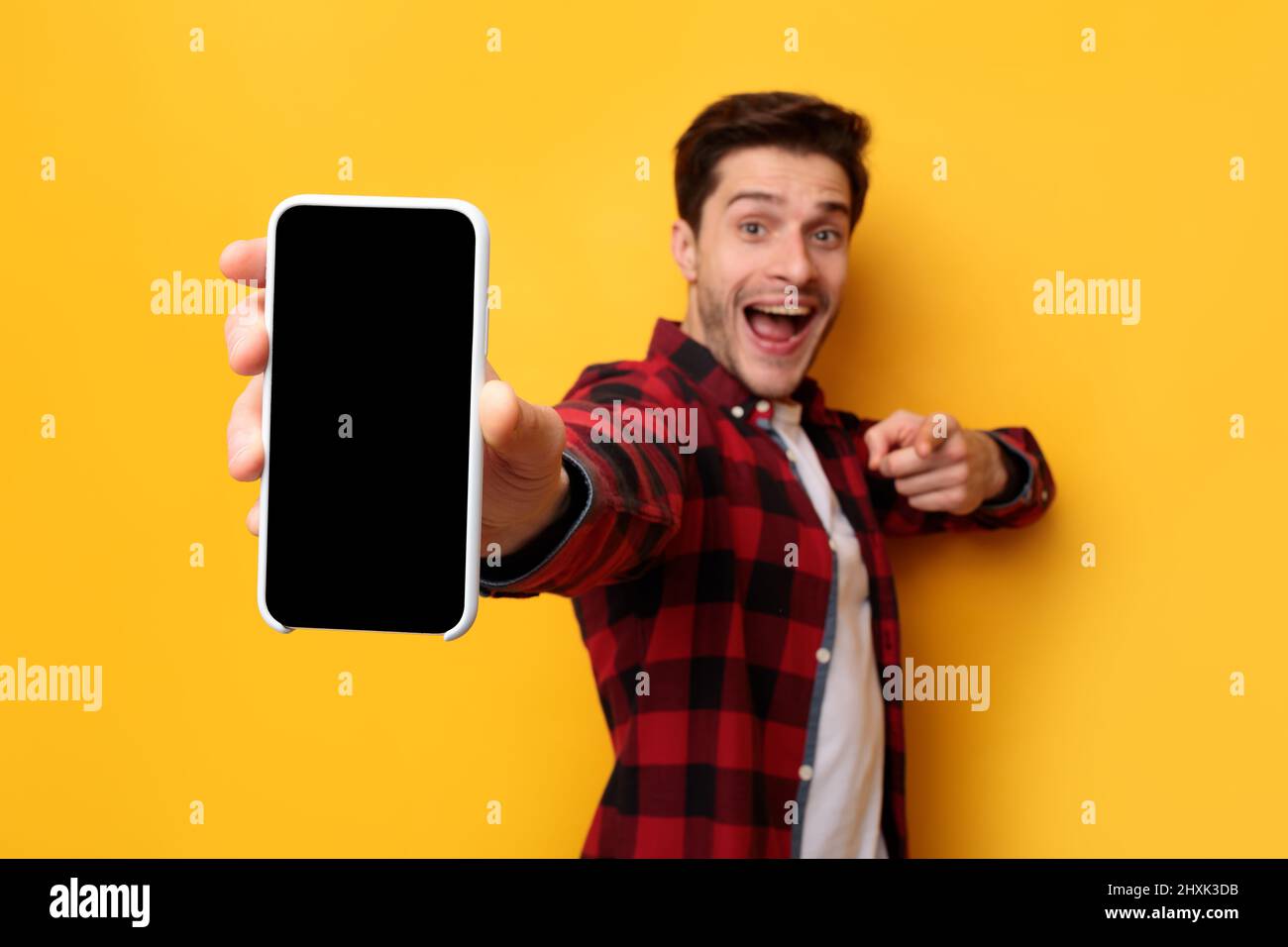 Un ragazzo scioccato che punta allo schermo vuoto dello smartphone Foto Stock