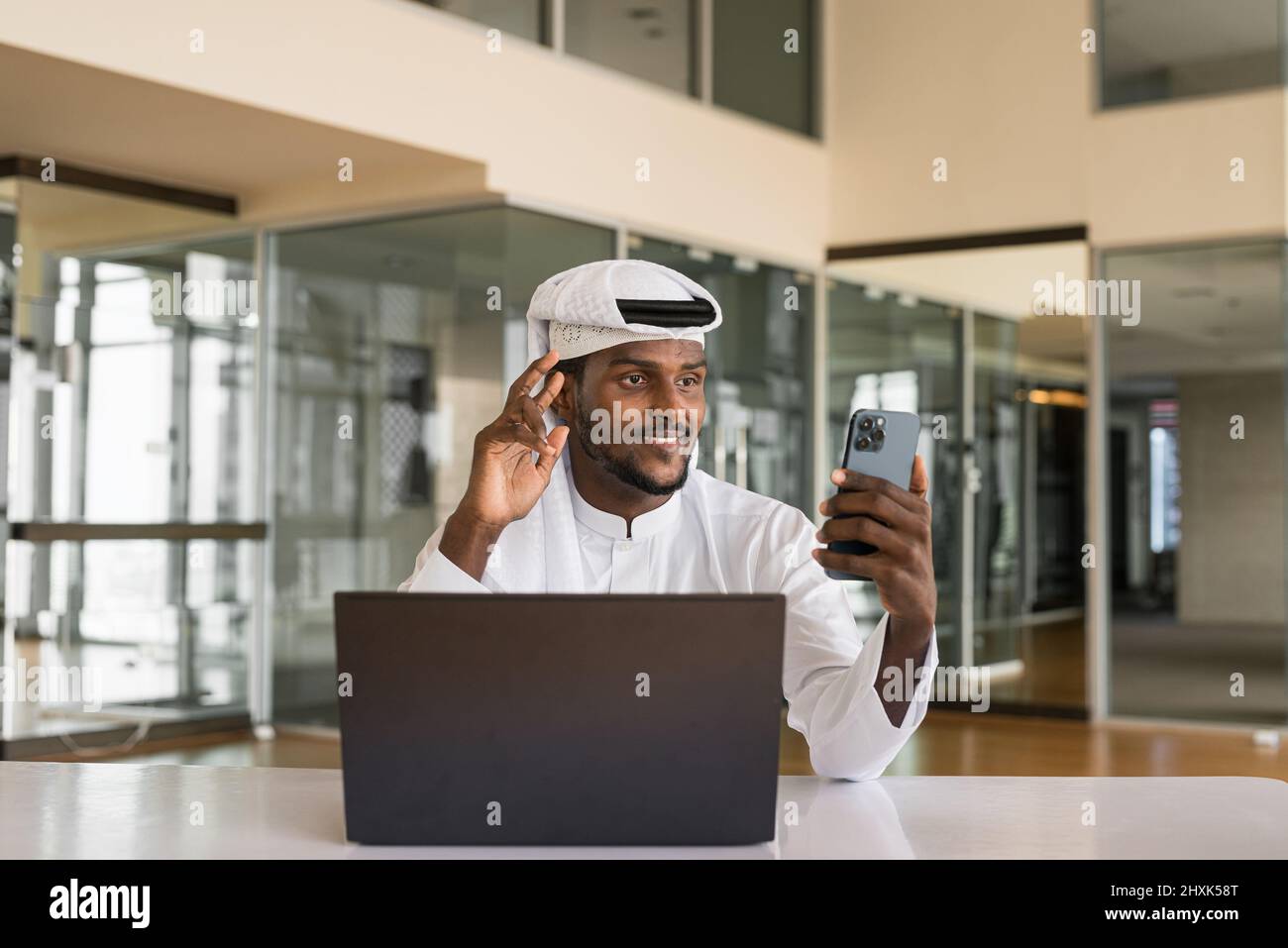 Uomo musulmano africano che usa un computer portatile in ufficio Foto Stock