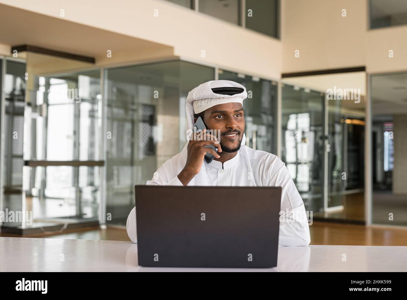 Uomo musulmano africano che usa un computer portatile in ufficio Foto Stock