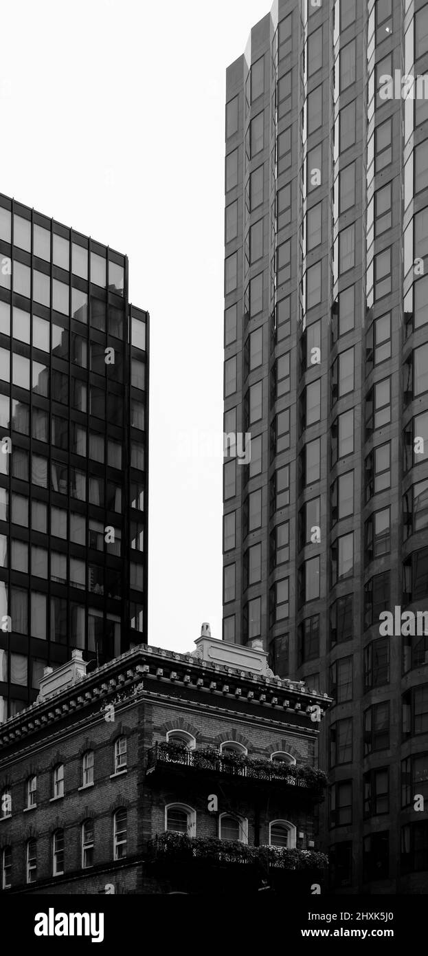 B&W grattacieli moderni in contrasto con un vecchio pub inglese a Victoria, nel centro di Londra, Regno Unito Foto Stock