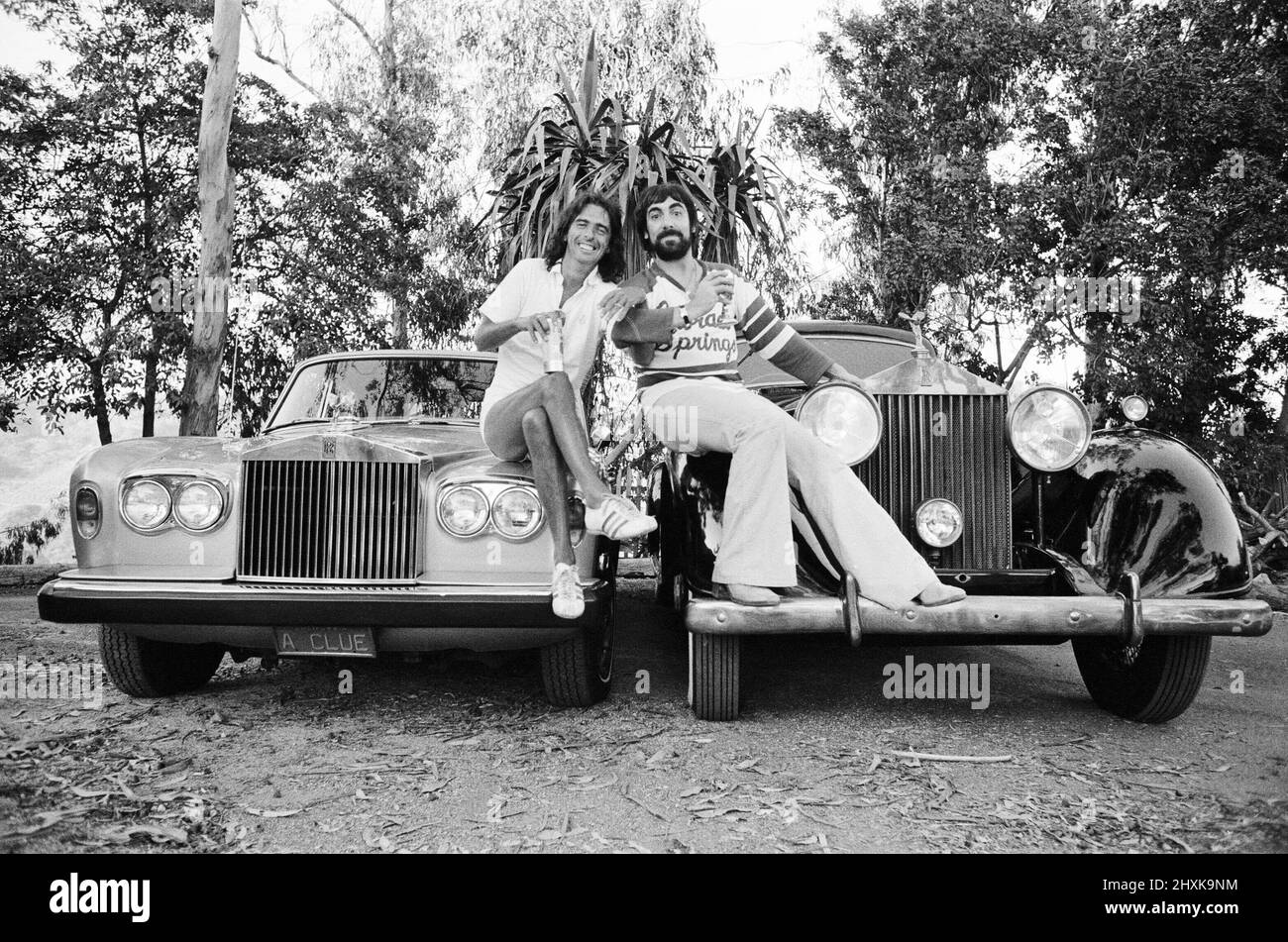 Keith Moon, batterista del gruppo rock dell'OMS e rock star americana Alice Cooper posano con le loro nuove Rolls Royce automobili che hanno comprato in spending spree a Malibu, California. Cooper ha acquistato un'ombra d'argento del 1976 mentre Moon è andato meglio con un fantasma. Foto scattata il 25th luglio 1976. Foto Stock