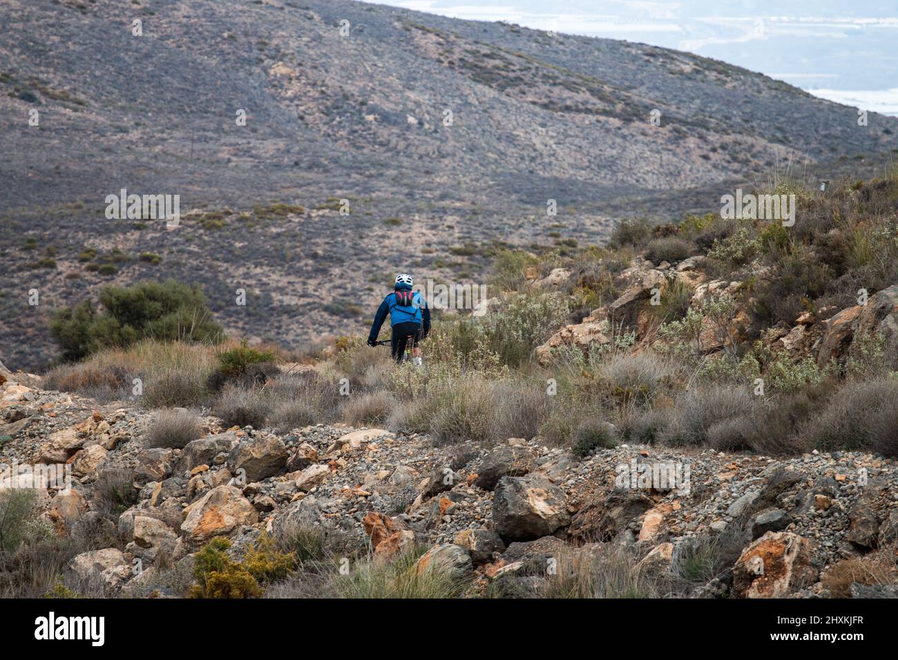 Ciclista a cavallo di una bicicletta su un sentiero sterrato nelle montagne in Spagna Foto Stock