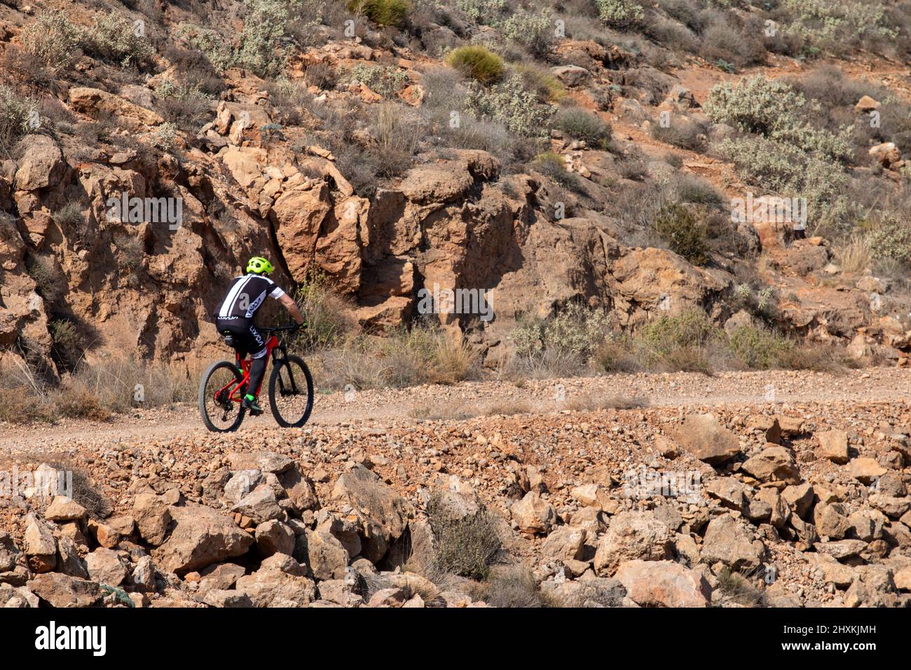Ciclista a cavallo di una bicicletta su un sentiero sterrato nelle montagne in Spagna Foto Stock