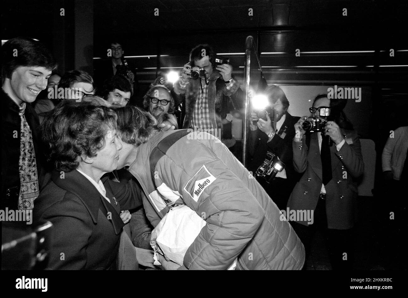 James Hunt, il nuovo campione del mondo di corse automobilistiche, ha ricevuto il benvenuto di un eroe quando ha volato all'aeroporto di Heathrow questa mattina dal Giappone. Il pilota di Formula uno della McLaren di 29 anni è stato accolto dalla maggior parte della sua famiglia e fidanzata Jane Birbeck. L'immagine mostra il saluto di James e baciare la sua madre felice, sue Hunt. Foto scattata 26th October1976 Foto Stock