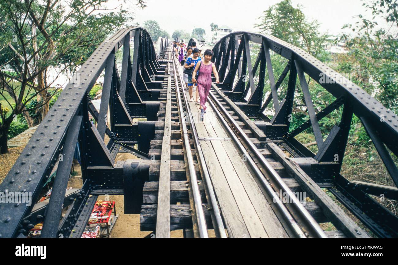 Ogni giorno migliaia di turisti attraversano il famoso ponte sul fiume Kwai a Kanchanaburi in treno e a piedi. Foto Stock