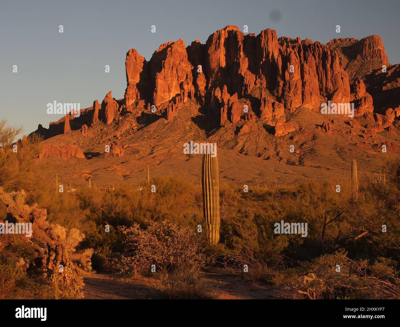 Immagini del tramonto a Superstition Mountain in Arizona e dintorni. Il sole che tramonta bagna la zona in tonalità dorate di rosso. Foto Stock