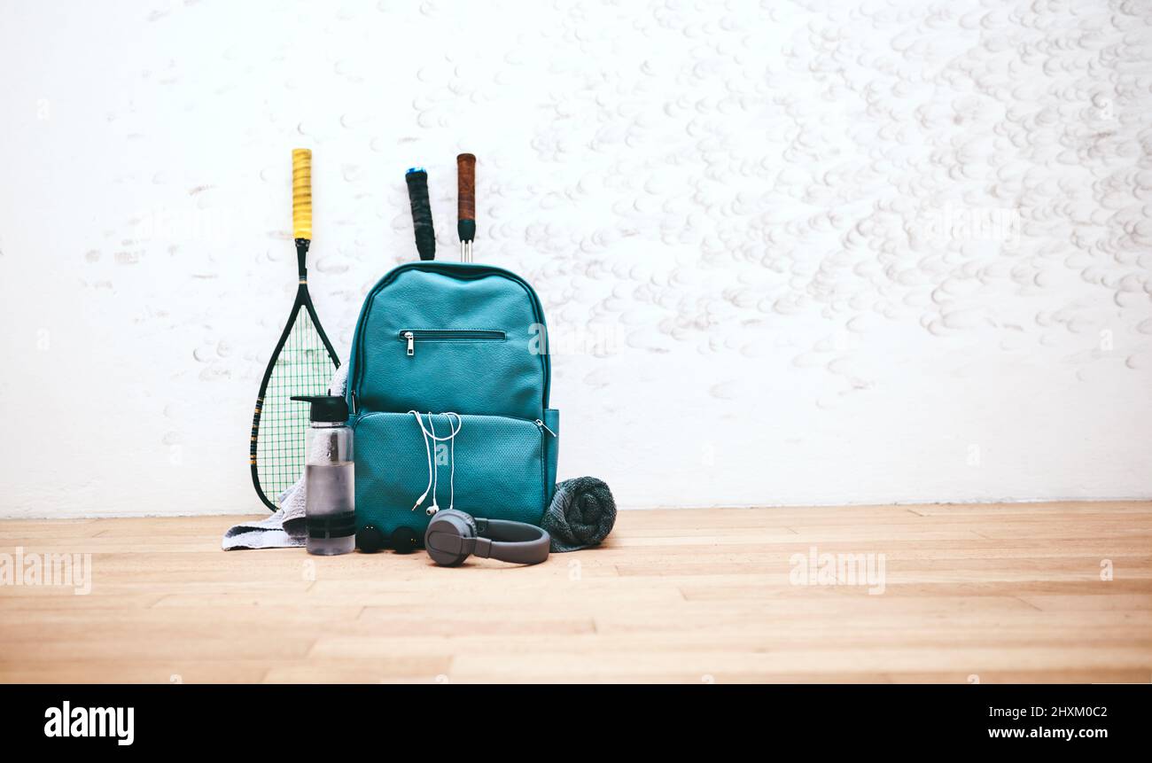 Attrezzatura adatta a un professionista. Shot di una borsa sportiva e altri articoli in un campo da squash vuoto. Foto Stock