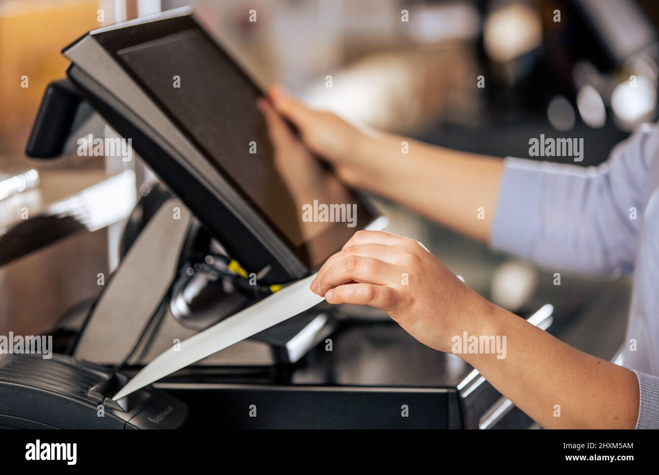 Processo di stampa della fattura per un cliente, processore di carte di credito, stampante per ricevute con bolletta della spesa cartacea e monitor touchscreen, POS Foto Stock