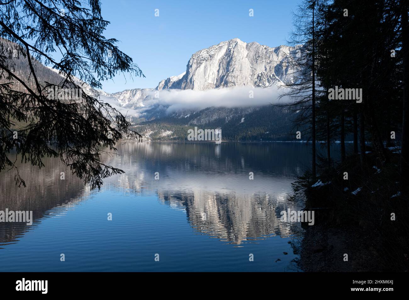 La montagna del Trisselwand si riflette nel lago di Altaussee nel pomeriggio invernale Foto Stock