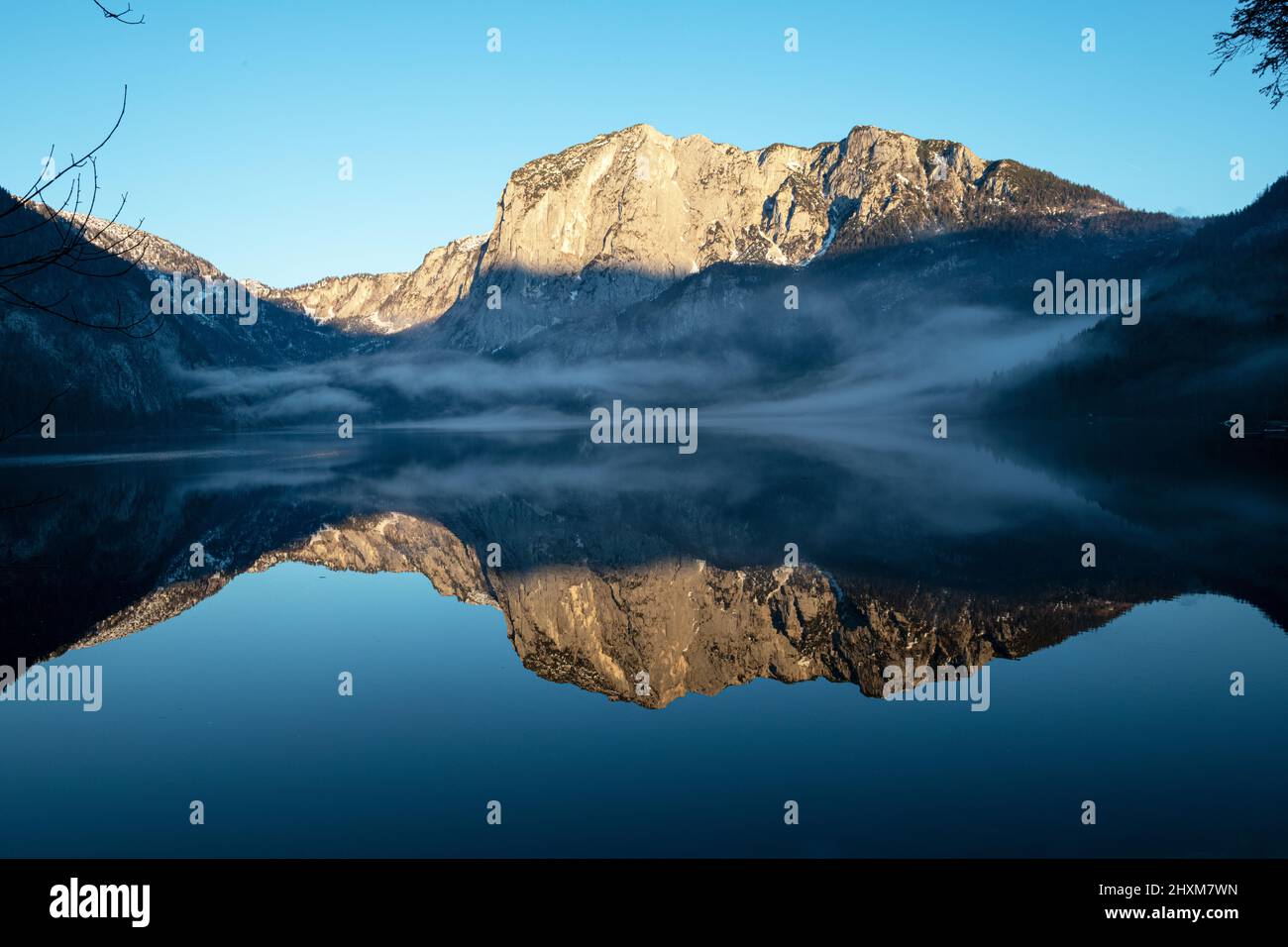 La montagna del Trisselwand si riflette nel lago di Altaussee nel pomeriggio invernale Foto Stock