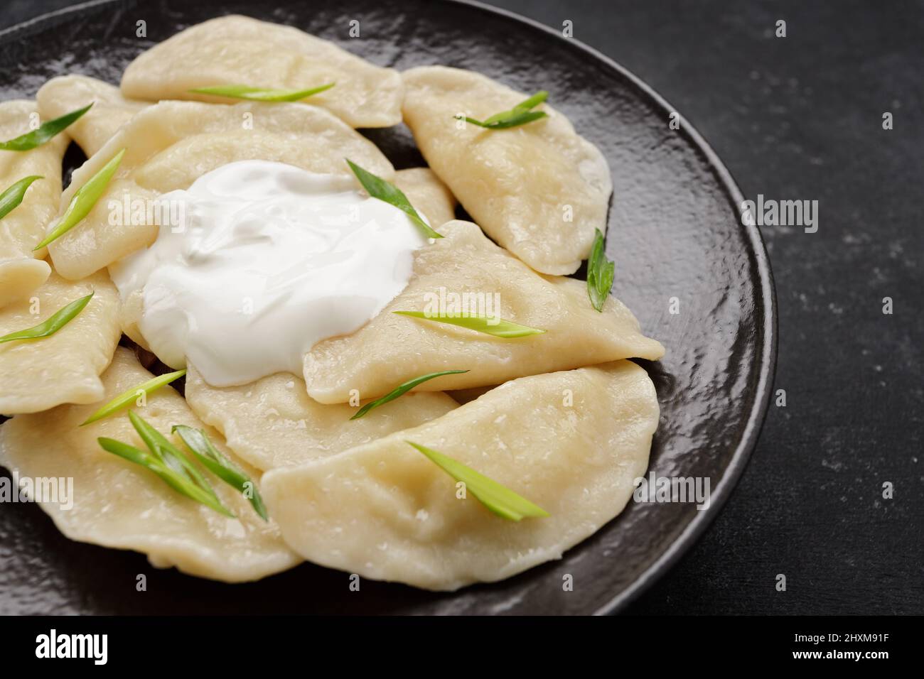 Gnocchi ucraini bolliti su sfondo scuro, con spazio per il testo Foto Stock