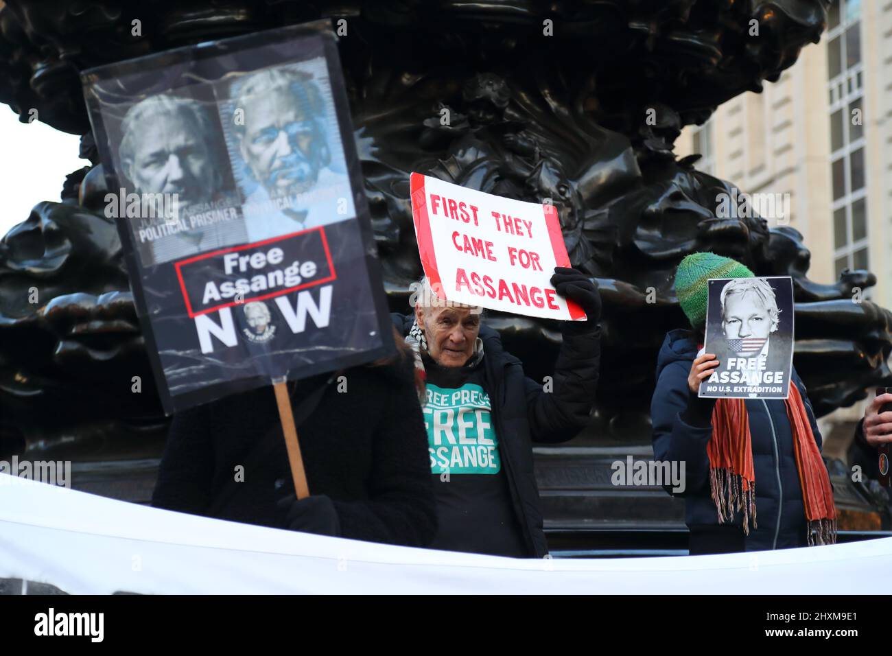 Un piccolo gruppo di dimostranti che hanno in mano dei cartelli per liberare Julian Assange dalla prigione di Piccadilly Circus, Londra, Regno Unito Foto Stock
