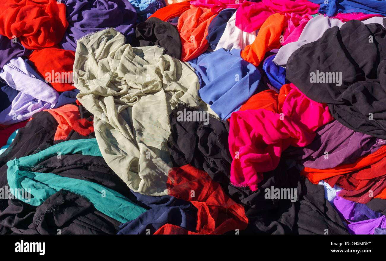 Pelo pezzo di colorato tessuto vista superiore in donna produttore bazar, luminoso abbigliamento caotico stack sfondo. Foto Stock