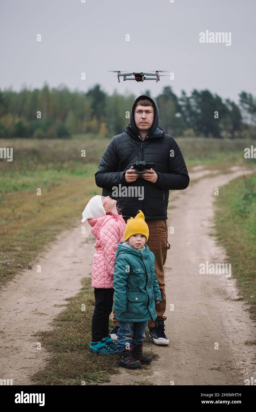 Famiglia felice con due bambini che giocano con drone nel campo autunno tempo. Foto Stock