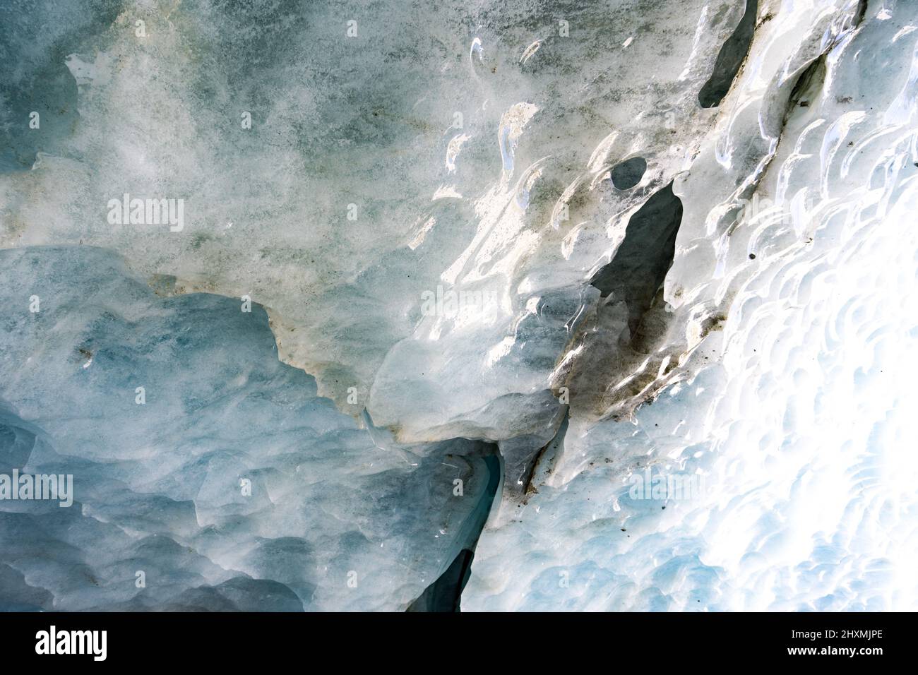 Rompendo il ghiaccio nel ghiacciaio, il ghiaccio parete trama preso da una grotta naturale del ghiacciaio in Zinal, Svizzera Foto Stock