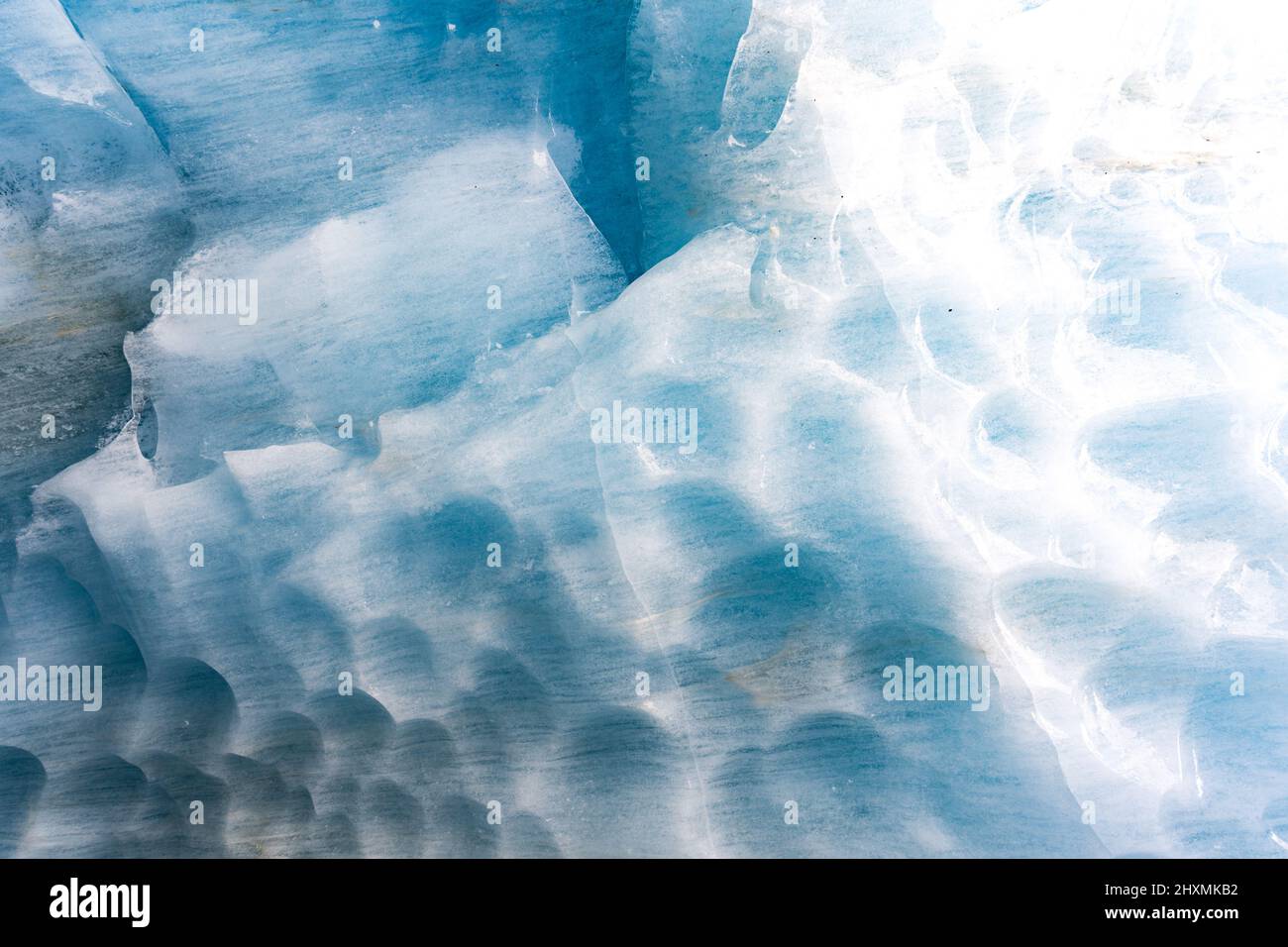 Rompendo il ghiaccio nel ghiacciaio, il ghiaccio parete trama preso da una grotta naturale del ghiacciaio in Zinal, Svizzera Foto Stock