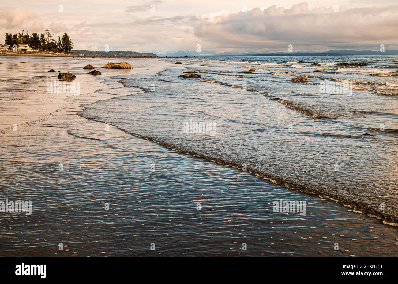 Bassa marea su una spiaggia a sud di Campbell River, sull'isola di Vancouver, B.C. la spiaggia piana e sabbiosa con mucchi di legno secco è un luogo preferito per camminare. Foto Stock