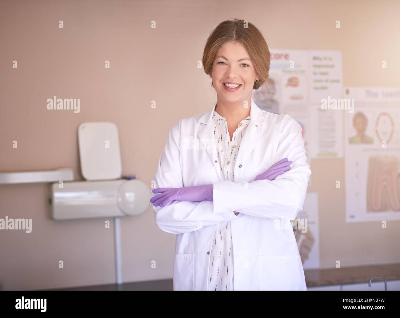 Ill migliora il tuo sorriso aspetto con piacere. Ritratto di una dentista femminile in piedi nel suo ufficio con le braccia incrociate. Foto Stock
