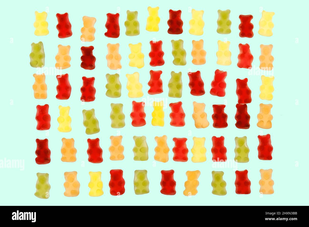 Gelatina porta caramelle isolato su uno sfondo blu.Jelly dolci a basso contenuto calorico. Dessert.Jelly multicolore orsi assortiti.Sweet pattern in giallo Foto Stock