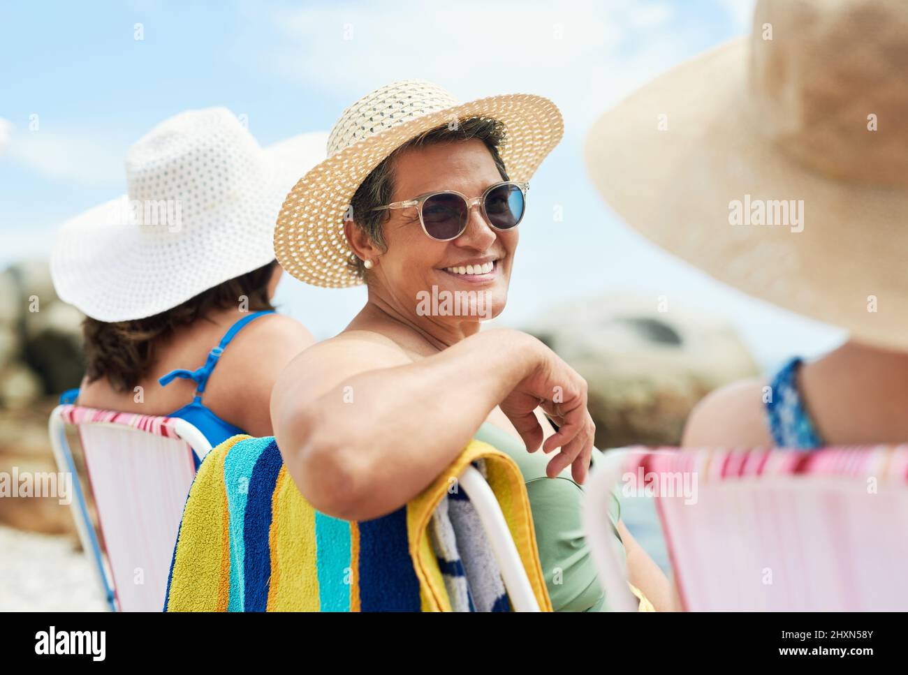 Erano un gruppo di donne mature che estendono la fiducia agli altri. Scatto di una donna matura seduta e godere di una giornata sulla spiaggia con gli amici. Foto Stock