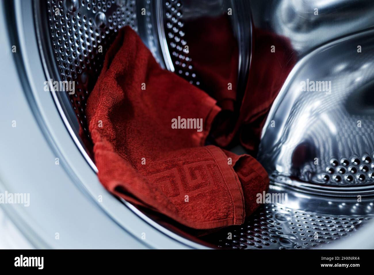 asciugamano di cotone rosso nella lavatrice. pulizia e lavanderia Foto Stock