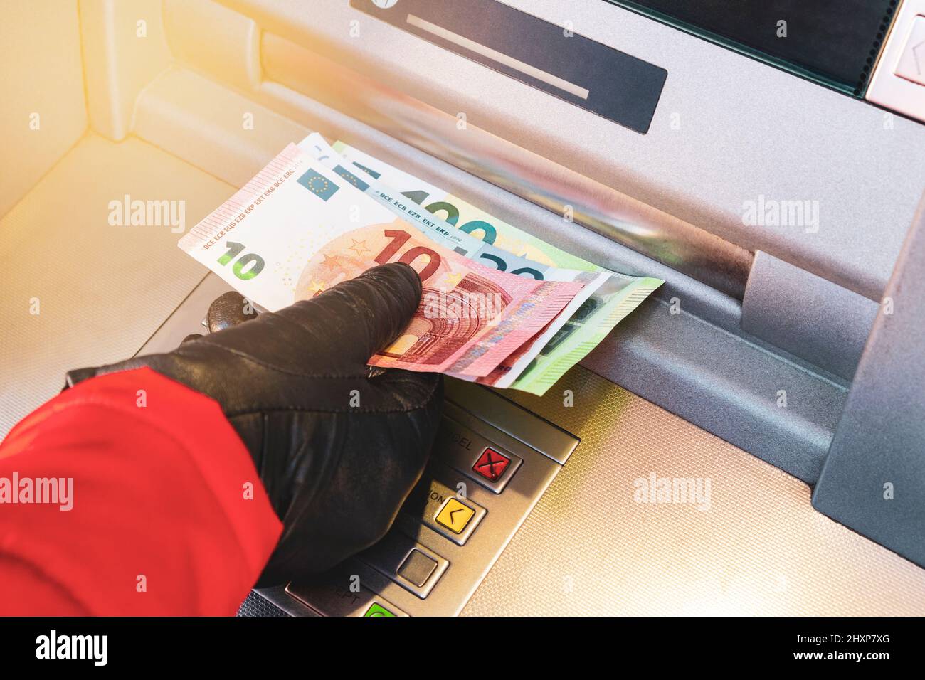 Mano donna che preleva denaro da bancomat banca esterna. Mano femminile che prende le banconote in euro dalla macchina bancaria. Foto Stock