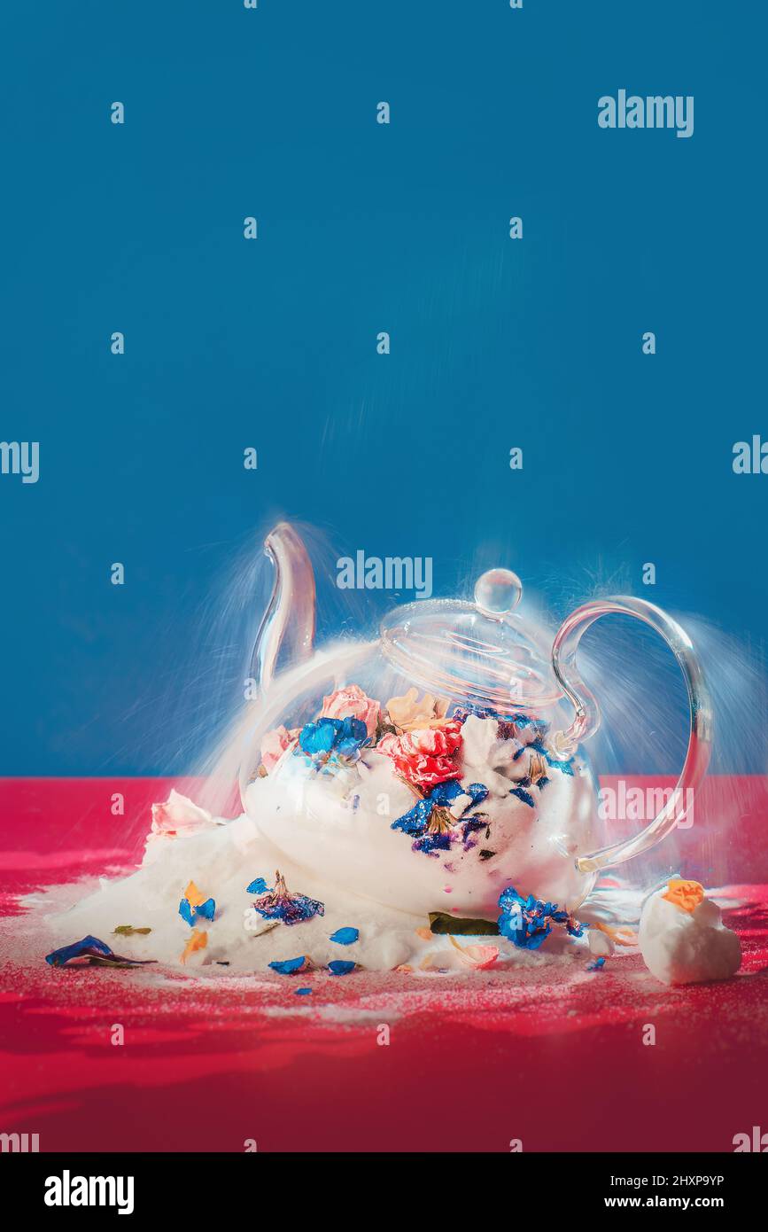 Tavolozza blu e rosa, teiera rotta con fiori, velocità dell'otturatore lunga Foto Stock