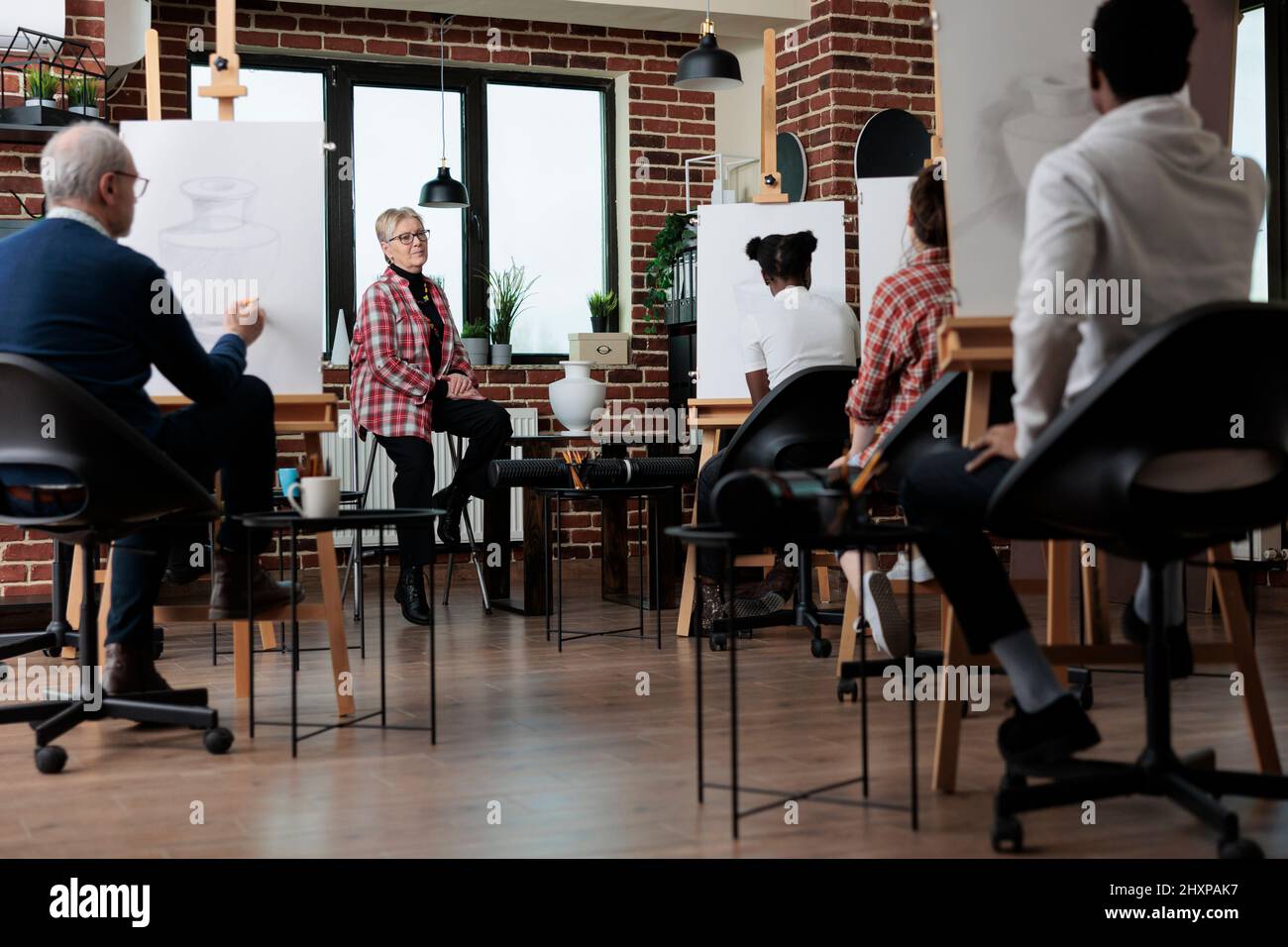 Creativo giovane studente disegno vase modello su tela di lavoro a illustrazione grafica durante la classe d'arte in studio scuola. Gruppo di persone multietniche che imparano nuove abilità di disegno. Concetto artistico Foto Stock