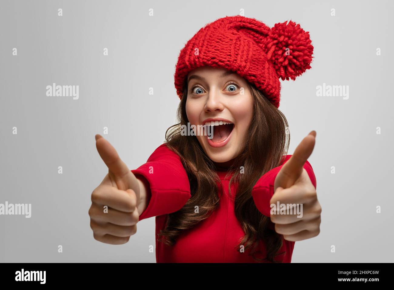 La ragazza mostra come la macchina fotografica, indossando un cappello di Capodanno, concentrarsi sul viso Foto Stock