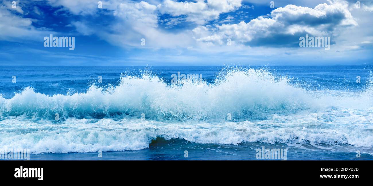 Luminoso paesaggio oceano panoramico in tonalità blu. Onde di mare e bel cielo con nuvole bianche. Foto Stock
