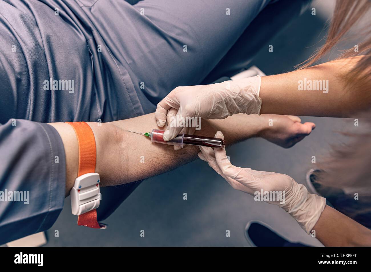 Nurse che prende un campione di sangue dalla vena del braccio con un vacutainer. Procedura di venipuntura o venopuntura Foto Stock