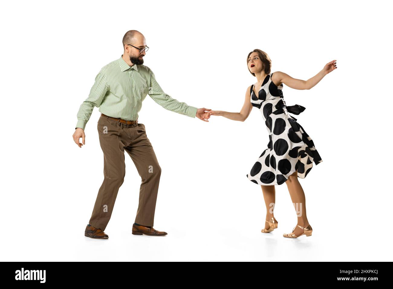 Ritratto dinamico di coppia di ballerini in abiti vintage stile retrò danza lindy hop danza isolato su sfondo bianco. Concetto di arte, azione Foto Stock