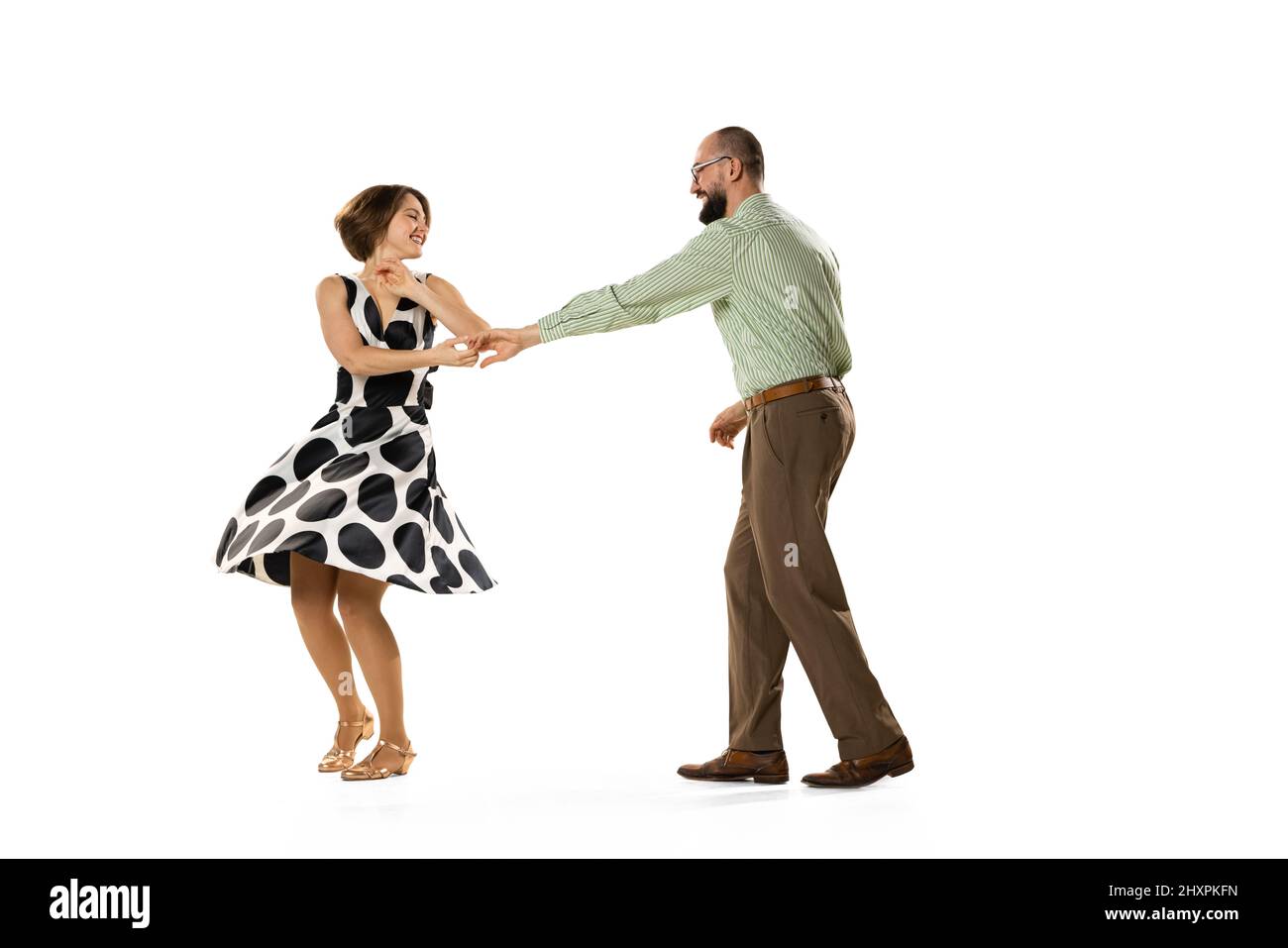 Ritratto dinamico di coppia di ballerini in abiti vintage stile retrò danza lindy hop danza isolato su sfondo bianco. Concetto di arte, azione Foto Stock