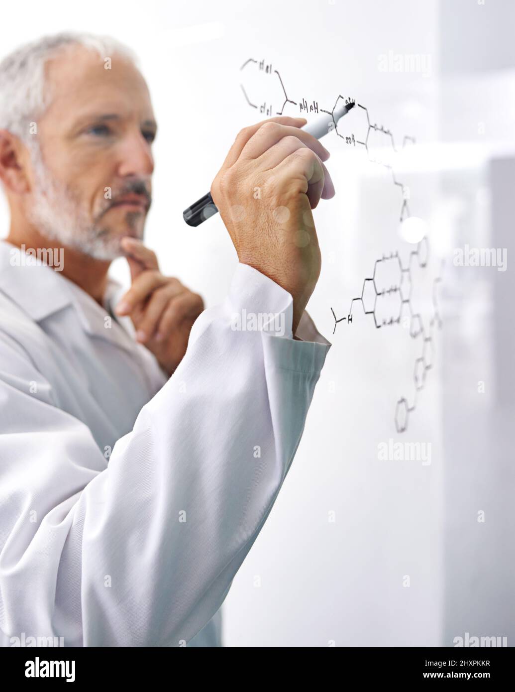 HES ha partecipato a ricerche all'avanguardia. Shot di uno scienziato maschio maturo che disegna una struttura molecolare su una superficie di vetro. Foto Stock