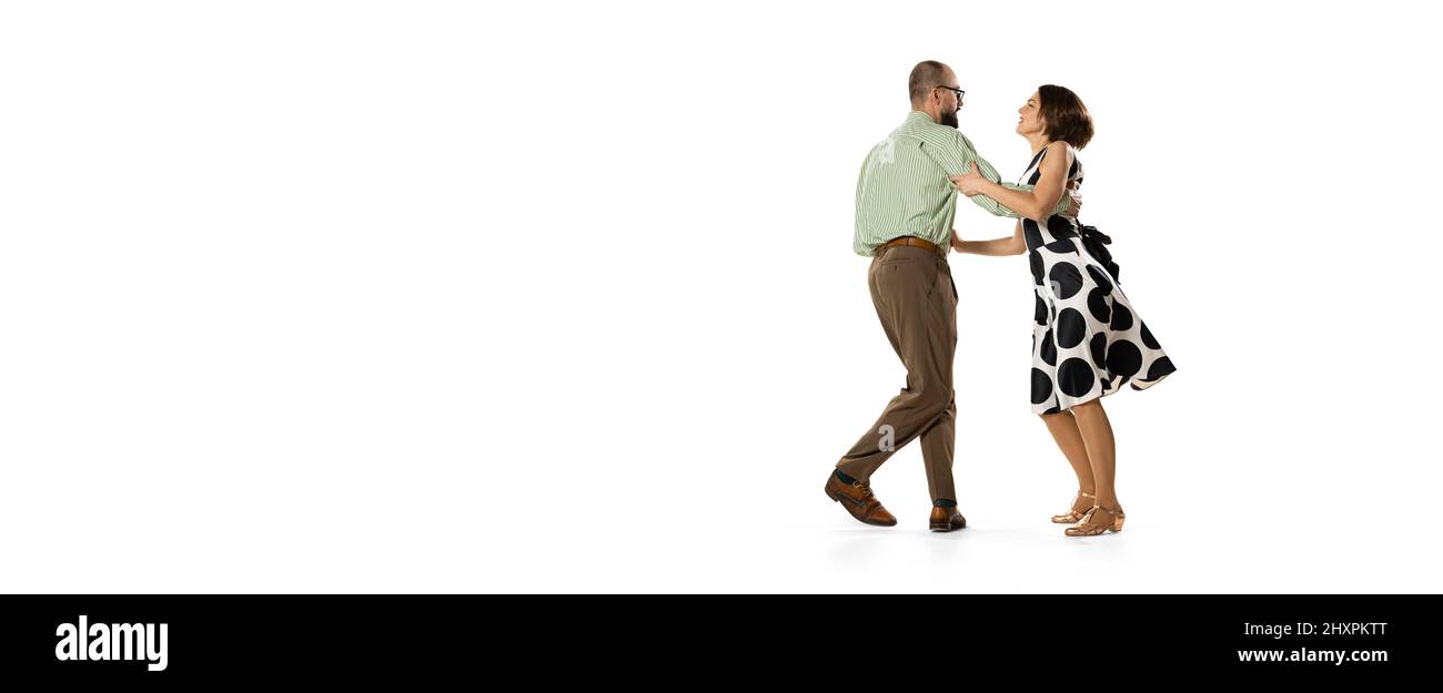 Ritratto dinamico di coppia di ballerini in abiti vintage stile retrò danza lindy hop danza isolato su sfondo bianco. Concetto di arte, azione Foto Stock