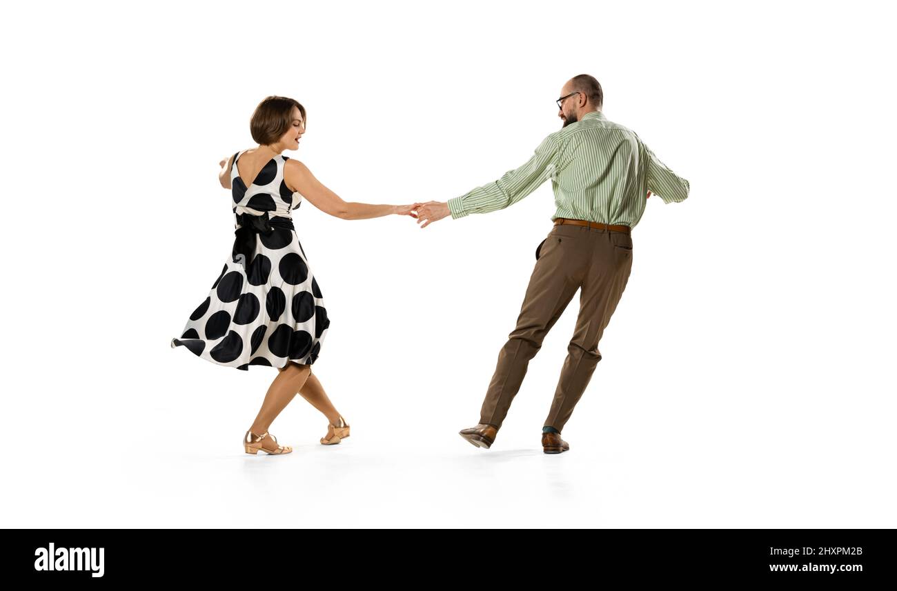 Ritratto dinamico di coppia di ballerini in abiti vintage stile retrò danza lindy hop danza isolato su sfondo bianco. Concetto di arte, azione Foto Stock
