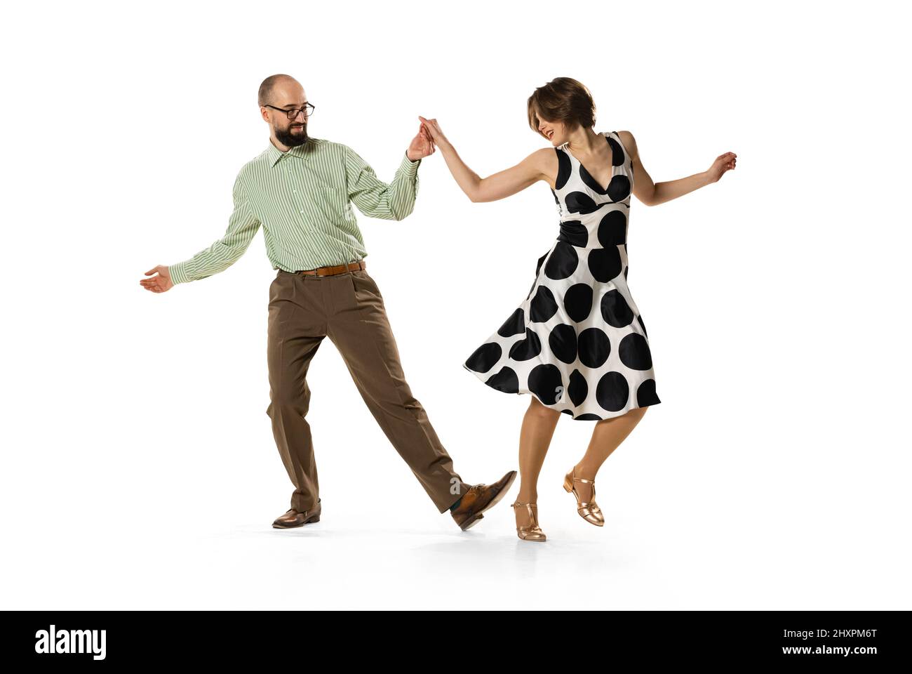 Ritratto dinamico di coppia di ballerini in abiti vintage stile retrò danza lindy hop danza isolato su sfondo bianco. Concetto di arte, azione Foto Stock