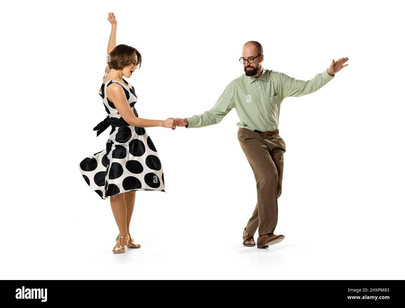 Ritratto dinamico di coppia di ballerini in abiti vintage stile retrò danza lindy hop danza isolato su sfondo bianco. Concetto di arte, azione Foto Stock