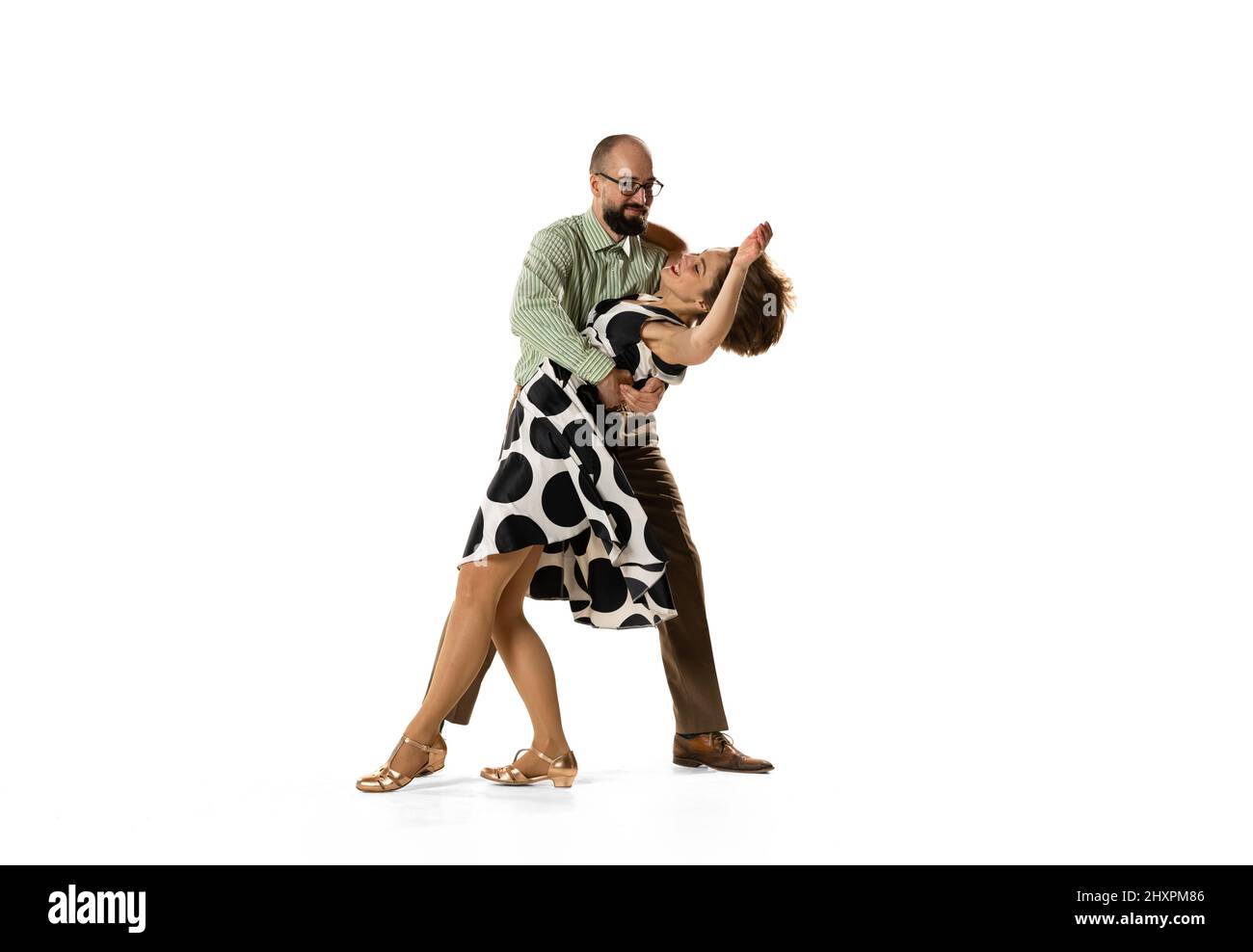 Ritratto dinamico di coppia di ballerini in abiti vintage stile retrò danza lindy hop danza isolato su sfondo bianco. Concetto di arte, azione Foto Stock